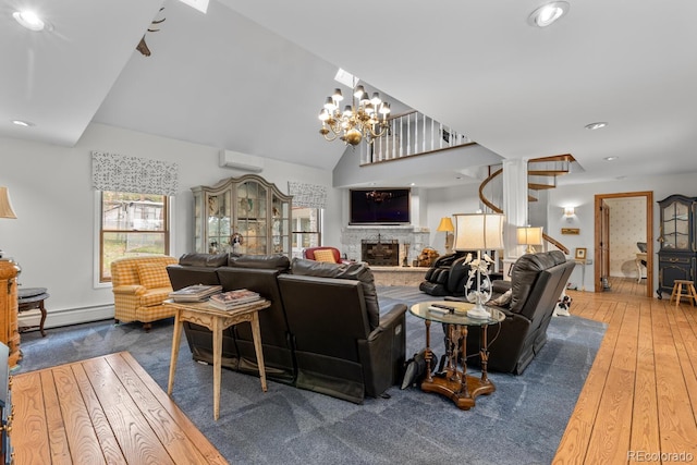 689 Red Deer Rd, Franktown, CO 80116 - living area featuring a baseboard heating unit, a wall mounted air conditioner, hardwood / wood-style flooring, stairs, and a fireplace with raised hearth