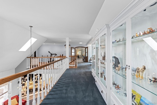 689 Red Deer Rd, Franktown, CO 80116 - hall featuring a skylight, arched walkways, french doors, an upstairs landing, and dark colored carpet