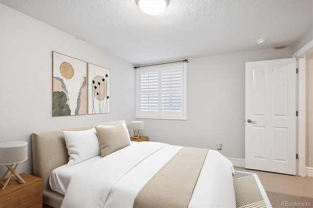 bedroom with light carpet and a textured ceiling