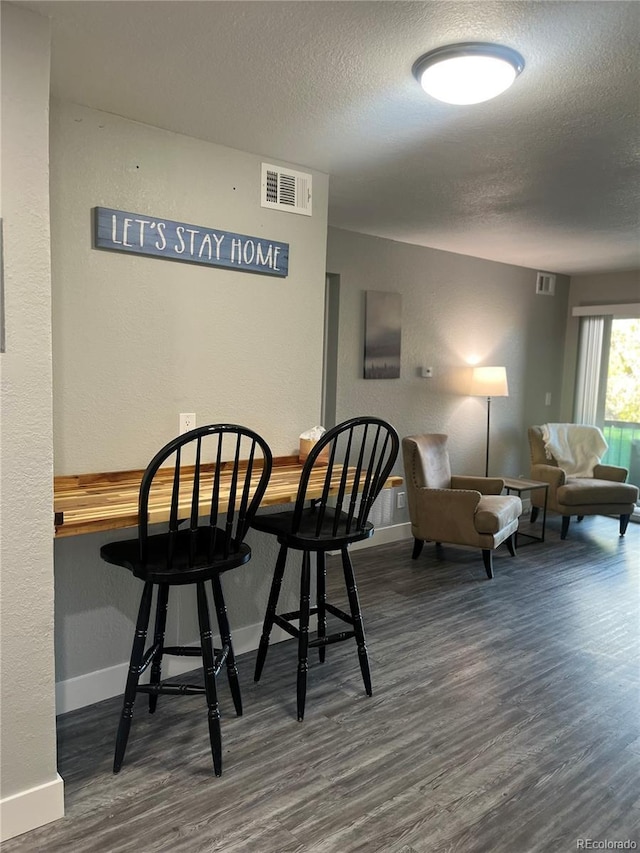 4899 S Dudley St Unit 1E, Littleton, CO 80123 - dining space with wood finished floors, baseboards, a textured ceiling, and a textured wall