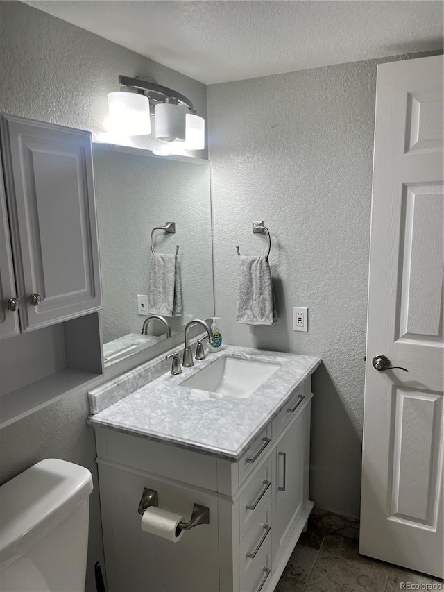 4899 S Dudley St Unit 1E, Littleton, CO 80123 - bathroom with vanity, a textured wall, toilet, and a textured ceiling