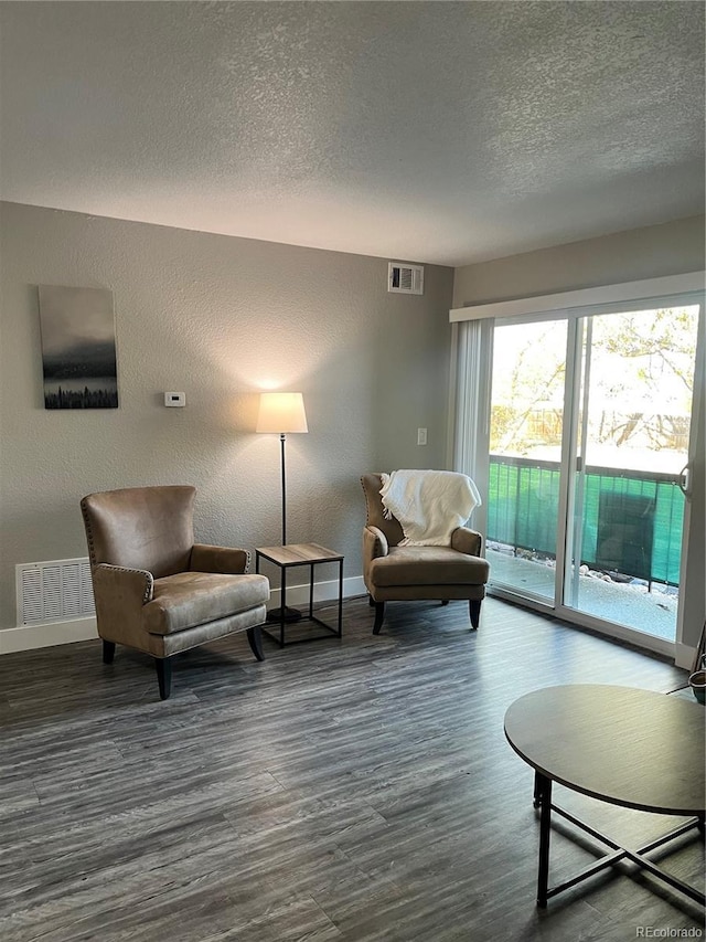 4899 S Dudley St Unit 1E, Littleton, CO 80123 - living area featuring a textured ceiling, wood finished floors, baseboards, and a textured wall
