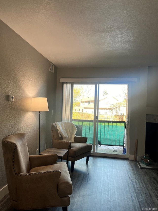 4899 S Dudley St Unit 1E, Littleton, CO 80123 - living room featuring wood finished floors, a textured wall, a textured ceiling, and baseboards
