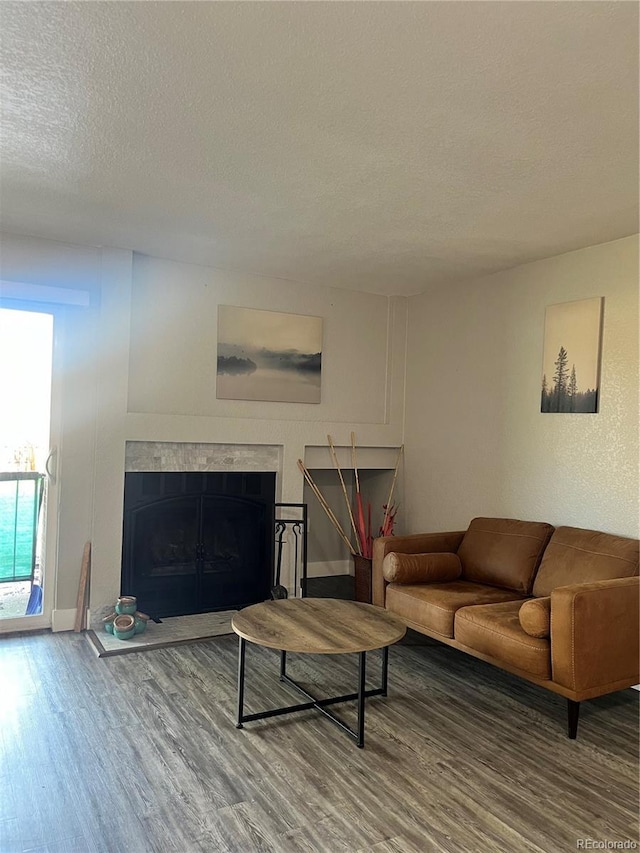 4899 S Dudley St Unit 1E, Littleton, CO 80123 - living area with wood finished floors, a high end fireplace, a textured ceiling, and baseboards