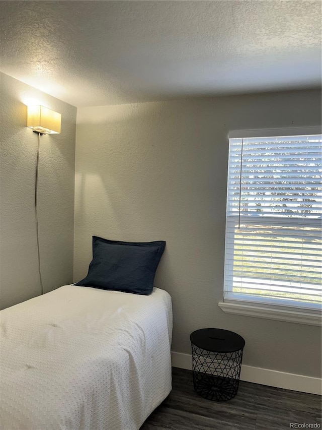 4899 S Dudley St Unit 1E, Littleton, CO 80123 - bedroom with baseboards, wood finished floors, and a textured ceiling