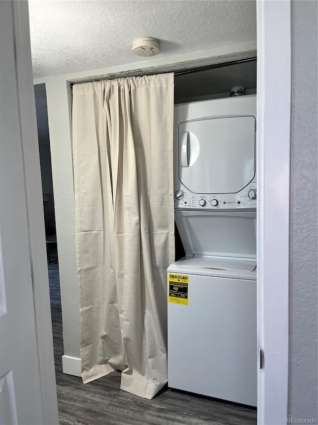 4899 S Dudley St Unit 1E, Littleton, CO 80123 - washroom with stacked washer / dryer, dark wood-style flooring, and a textured ceiling