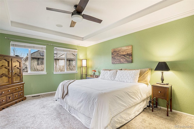 carpeted bedroom featuring baseboards, a raised ceiling, visible vents, and a ceiling fan