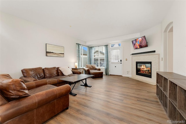 7860 E Ellsworth Ave, Denver, CO 80230 - living area featuring a glass covered fireplace, light wood-style flooring, arched walkways, and baseboards