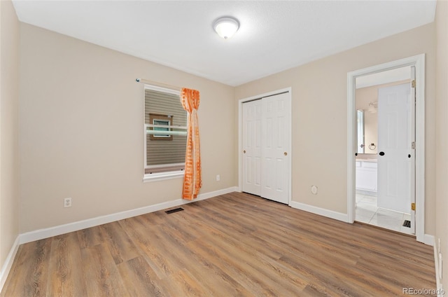 7860 E Ellsworth Ave, Denver, CO 80230 - unfurnished bedroom featuring wood finished floors, baseboards, connected bathroom, and a closet