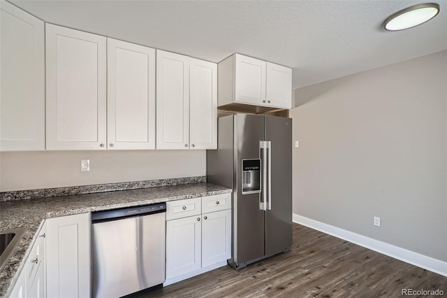 kitchen featuring dark hardwood / wood-style flooring, white cabinets, and appliances with stainless steel finishes