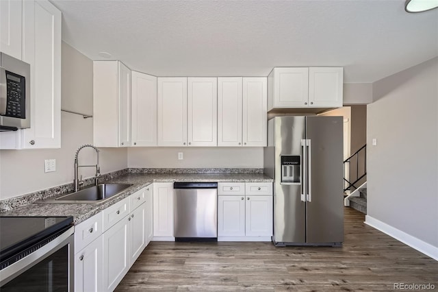 kitchen with white cabinetry, appliances with stainless steel finishes, dark hardwood / wood-style floors, and sink