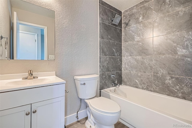 full bathroom with vanity, tiled shower / bath, and toilet