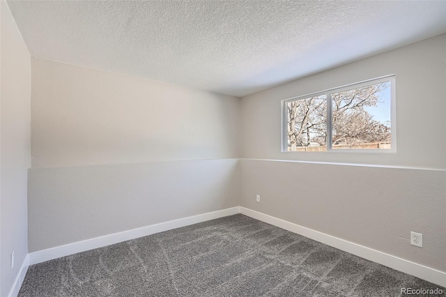 empty room featuring a textured ceiling and carpet