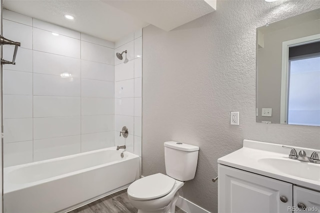 full bathroom with vanity, tiled shower / bath combo, wood-type flooring, and toilet