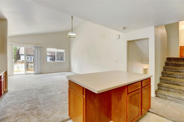 kitchen featuring pendant lighting, lofted ceiling, a center island, a textured ceiling, and light carpet