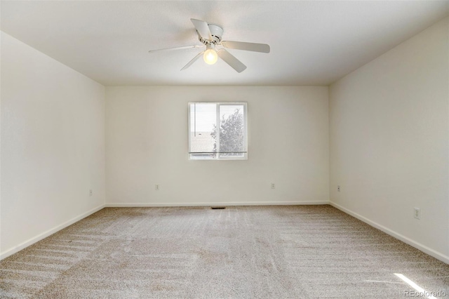 spare room featuring light colored carpet and ceiling fan