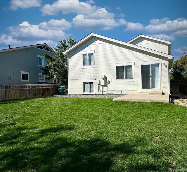 back of property with a yard and a patio