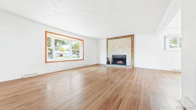 unfurnished living room featuring a large fireplace and light wood-type flooring