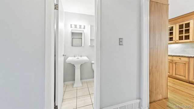 bathroom with backsplash, wood-type flooring, and sink