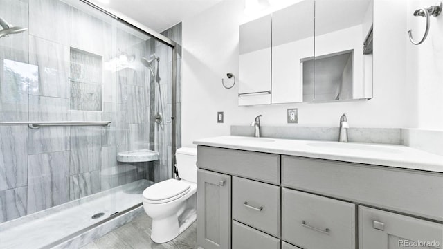 bathroom featuring vanity, toilet, and a shower with shower door