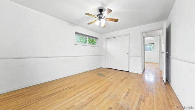 unfurnished bedroom with a closet, light hardwood / wood-style floors, and ceiling fan