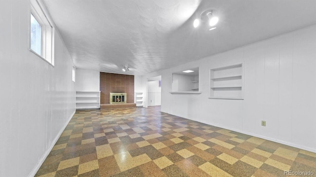 unfurnished living room with a fireplace and built in shelves