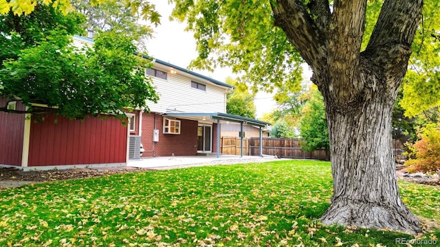 back of property with a yard and a patio area