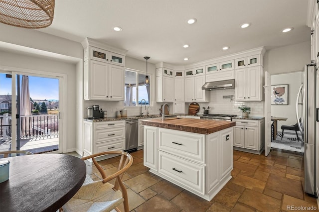 854 Countrybriar Ln, Highlands Ranch, CO 80129 - kitchen with butcher block countertops, stone tile flooring, recessed lighting, an island with sink, and decorative backsplash