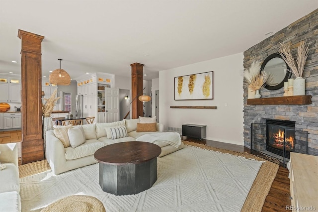 854 Countrybriar Ln, Highlands Ranch, CO 80129 - living room featuring decorative columns, wood finished floors, a stone fireplace, and recessed lighting
