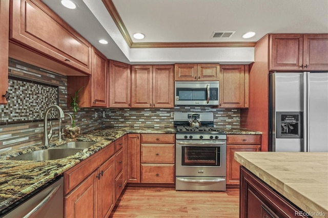 854 Countrybriar Ln, Highlands Ranch, CO 80129 - kitchen featuring stainless steel appliances, tasteful backsplash, light wood-style floors, dark stone countertops, and ornamental molding