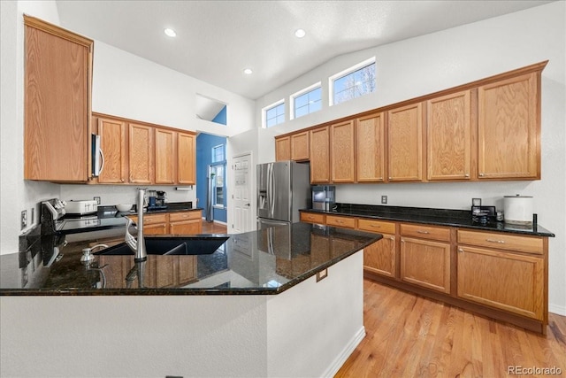 2730 River View Dr, Broomfield, CO 80023 - kitchen featuring appliances with stainless steel finishes, high vaulted ceiling, a peninsula, dark stone counters, and a sink
