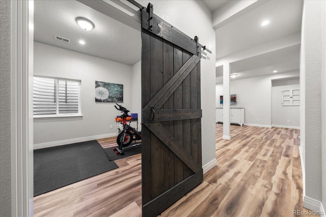 2730 River View Dr, Broomfield, CO 80023 - hall with a barn door, wood finished floors, baseboards, and recessed lighting