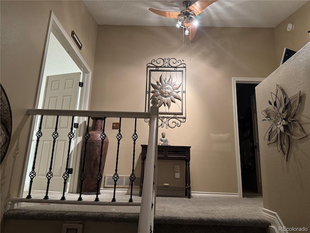 staircase with ceiling fan, carpet, visible vents, and baseboards