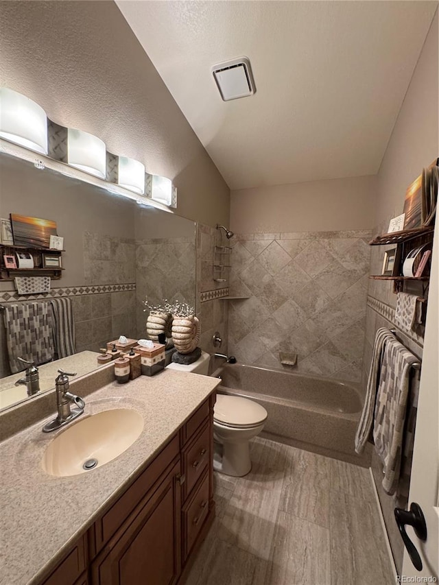 full bathroom with toilet, visible vents, vanity, vaulted ceiling, and shower / bathing tub combination