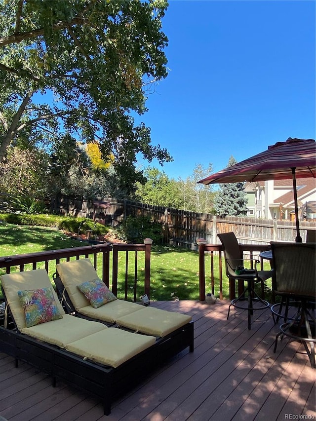 wooden terrace featuring fence and a yard