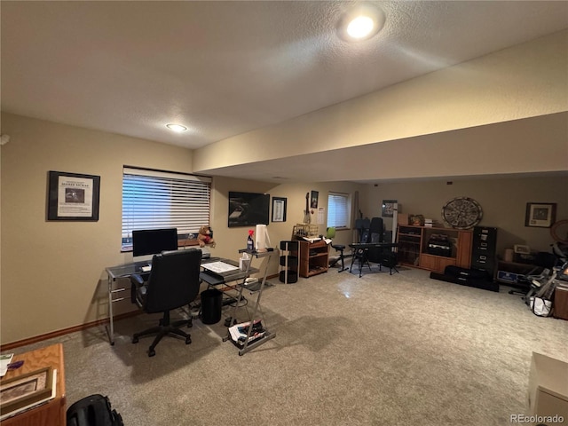 carpeted home office with a textured ceiling and baseboards