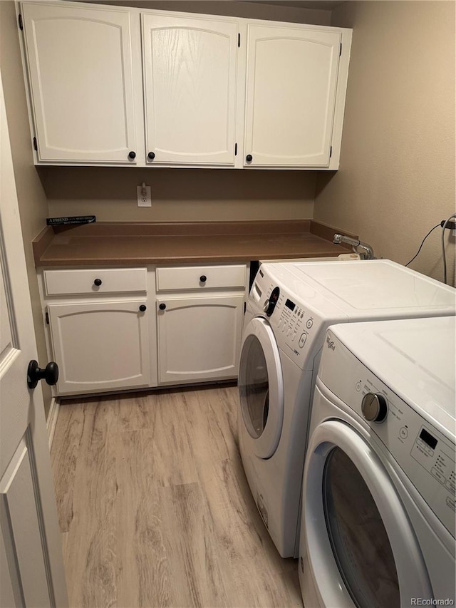 laundry room with cabinet space, light wood finished floors, and independent washer and dryer