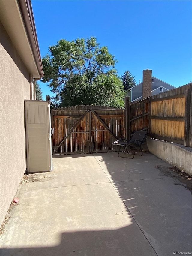 view of gate with a patio area and fence