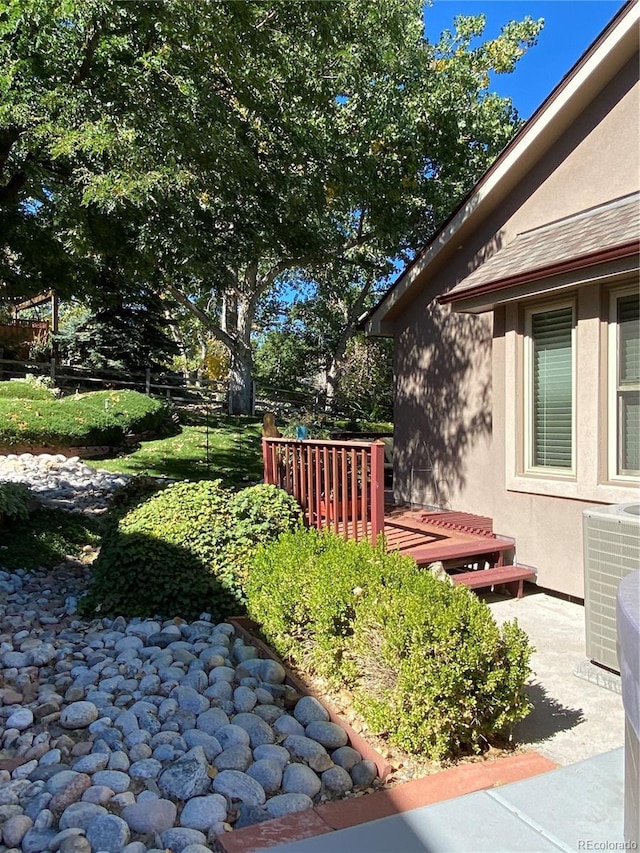 view of yard featuring a wooden deck and central air condition unit