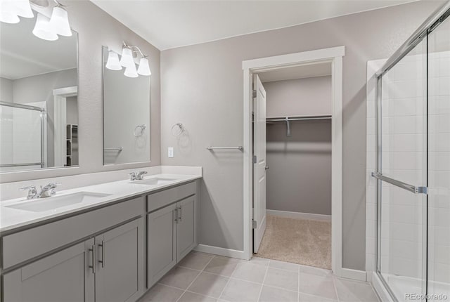 bathroom with tile patterned flooring, vanity, and a shower with door