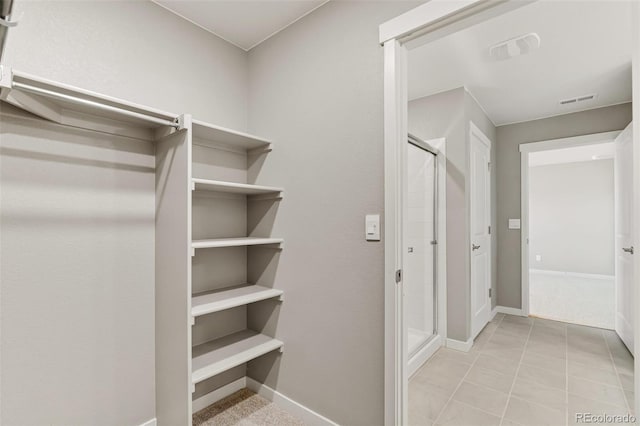 walk in closet with light tile patterned flooring