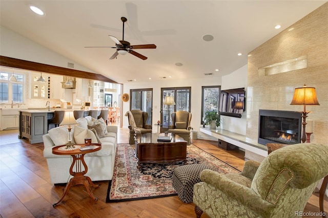 living room with a large fireplace, a wealth of natural light, and hardwood / wood-style floors