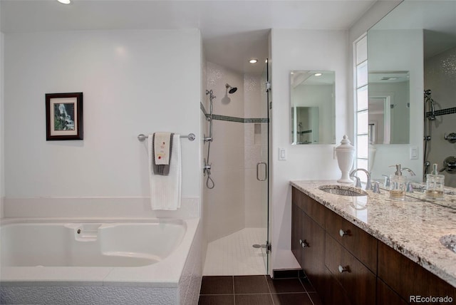 bathroom featuring plus walk in shower, vanity, and tile patterned floors