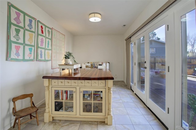 interior space with light tile patterned flooring and french doors