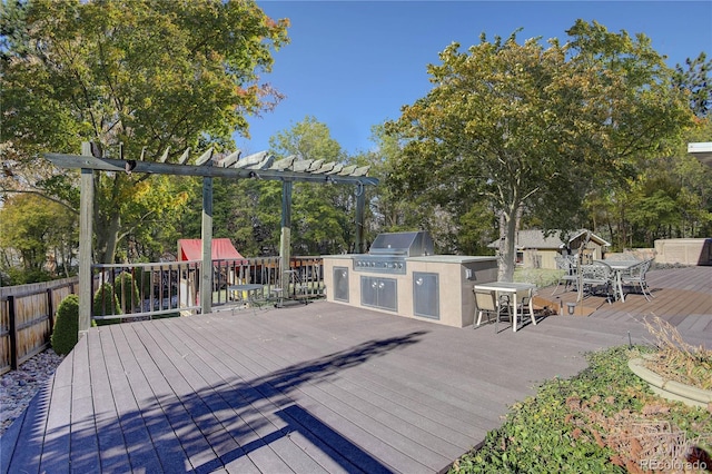 deck featuring a pergola, a grill, and exterior kitchen