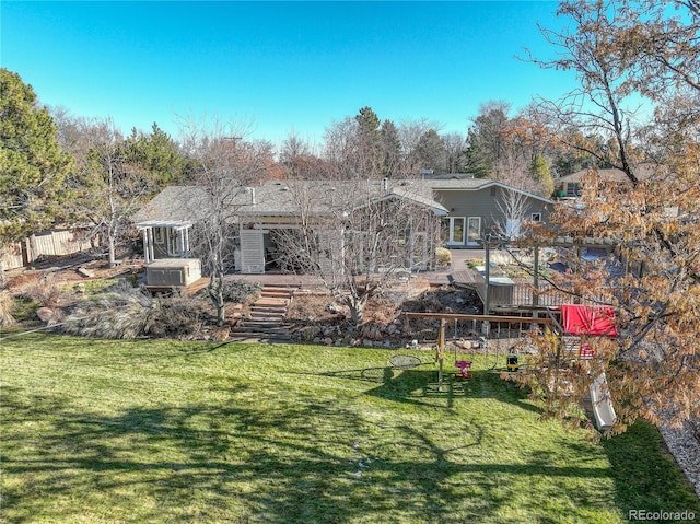 rear view of house featuring a yard and a wooden deck