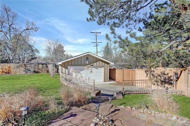 exterior space featuring a lawn, a garage, and an outbuilding