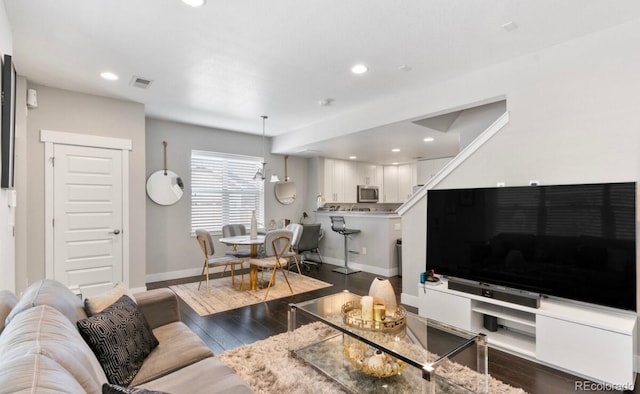 living room with a chandelier and dark hardwood / wood-style flooring