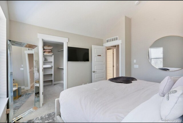 11255 E 25th Ave, Aurora, CO 80010 - bedroom with a walk in closet, a closet, carpet, visible vents, and vaulted ceiling