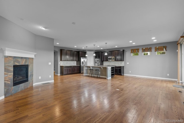 17223 W 84th Dr, Arvada, CO 80007 - unfurnished living room with light wood-style floors, a sink, recessed lighting, a fireplace, and baseboards